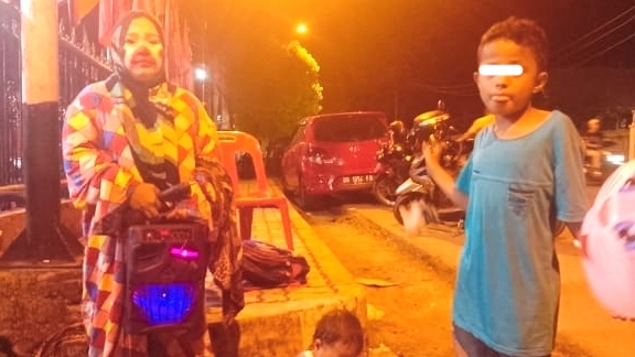 Siti Kholizah Lubis (39) dan kedua anak balitanya keliling dari warung ke kafe di sekitaran Padangsidimpuan demi untuk bisa mendapatkan uang recehan, Sabtu (15/4/2023) fhoto : istimewa.