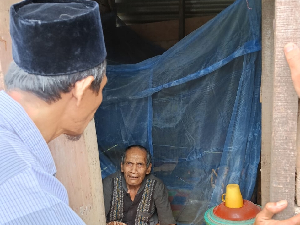 Wakil ketua l Baznas Madina Amir Mahmud menjenguk Kakek Deling Rangkuti yang tinggal sendirian di gubuk pengasingan, Jumat (28/4/2023) fhoto : istimewa.
