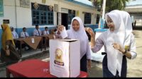Tampak dua siswi SMPN 1 Kotanopan memasukkan surat suara ke kotak suara yang disiapkan dalam pemilihan pengurus OSIS, Selasa (30/4/2024) fhoto : Istimewa.