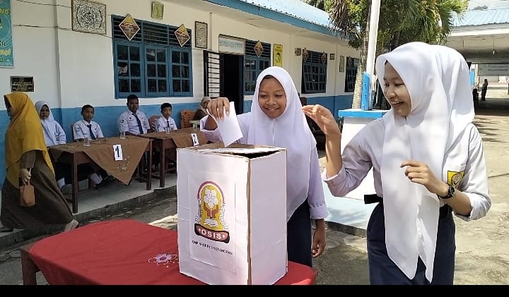 Tampak dua siswi SMPN 1 Kotanopan memasukkan surat suara ke kotak suara yang disiapkan dalam pemilihan pengurus OSIS, Selasa (30/4/2024) fhoto : Istimewa.